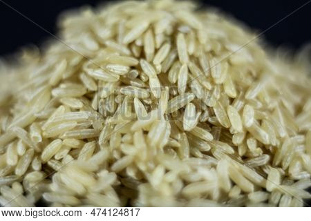 Studio Macro Shot Of A Pile Of Brown Rice, Also Called Complete, Integral Or Wholegrain Rice, With A