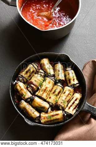 Eggplant (aubergine) Rolls With Cheese And Greens In Cast Iron Pan Over Dark Stone Background. Close