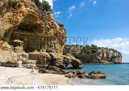Sandy Beach And Calm Turquoise Water Of Thracian Sea (mediterranean). Rock Covered By Vegetation. Bl