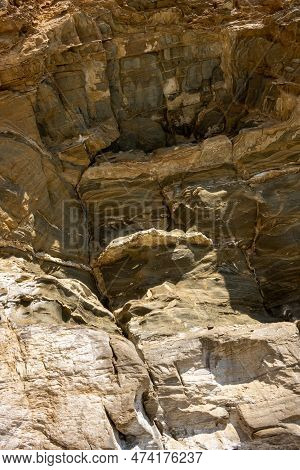 Structured Rock On A Side Of The Beach. Various Textures Of The Rough Material. Livadi Beach, Island