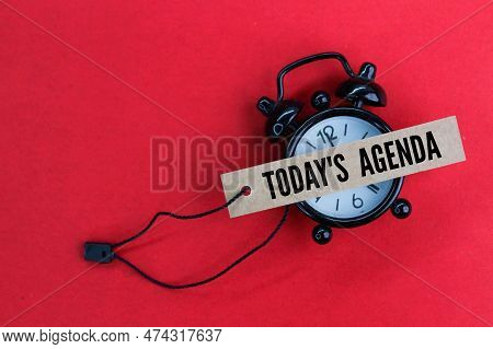 An Alarm Clock And A Paper Tag With The Words Today's Agenda. Today's Agenda Concept