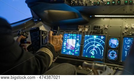 A Man Is Studying To Be A Pilot In A Flight Simulator. Close-up Of Male Hands Navigating An Aircraft