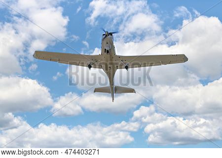Single Engine Ultralight Plane Flying In The Blue Sky With White Clouds