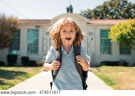 Funny School Boy Face. Child Pupul With Rucksacks In The Park Near School. Schoolboy With Backpacks 