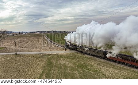 Ronks, Pennsylvania, December 27, 2022 - A Behind Aerial View Of A Steam Passenger Train Approaching