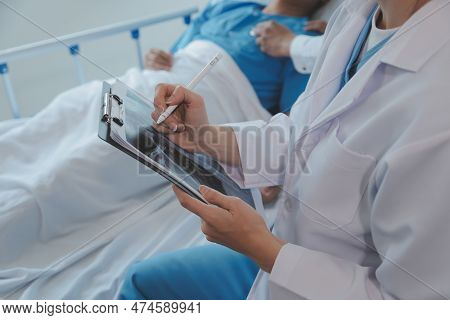 Injured Patient Showing Doctor Broken Wrist And Arm With Bandage In Hospital Office Or Emergency Roo