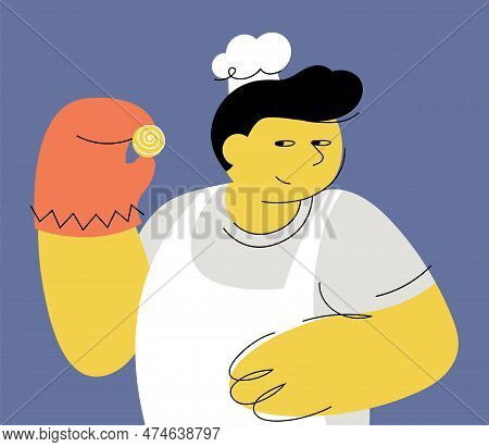Portrait Of Guy In White Apron And Hat, Holding Fresh Just-baked Cookie And Smiling. Man In Mitt Sho