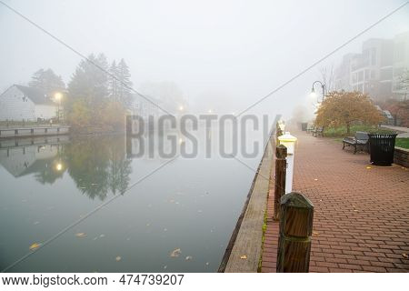 Brick Walkway In Foggy Morning Mist Along Historic Erie Canal With Traditional Two-story Houses, Mod