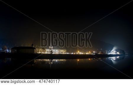 Night Photo On The Olt Valley - Romania With Many Buildings Reflecting In The Water