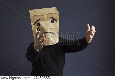 A Sad Man In A Black Turtleneck With A Bag On His Head, With A Drawn Crying Emoticon, Cries And Asks