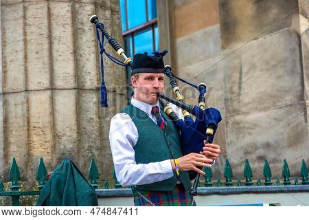Edinburgh, Uk - June 11, 2022: Bagpiper Playing Music With Bagpipe Near Edinburgh Castle In Edinburg
