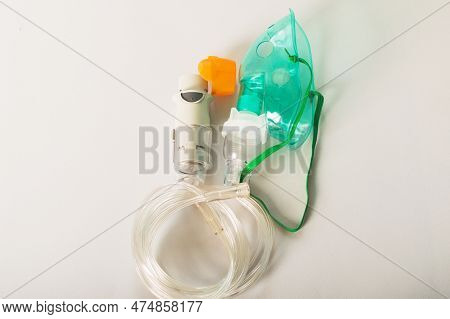 Bronchitis, Asthmatic Health Equipment. A Respiratory Mask And Inhaler Are On A Light Background.
