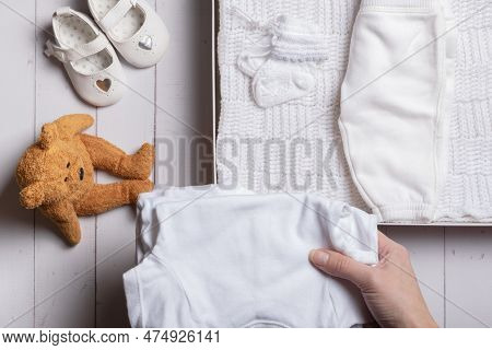 Female Hands Put Children's Clothes, Shoes And Toys Into A Box. Second Hand, Clothing Recycling Conc