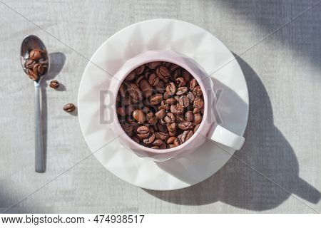 Coffee Beans In Cup On The Plate With Spoon