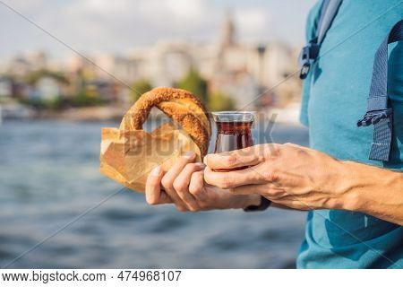 Man In Istanbul Having Breakfast With Simit And A Glass Of Turkish Tea. Glass Of Turkish Tea And Bag