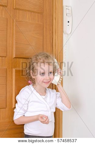 Little Girl Talking On The Intercom At Home.