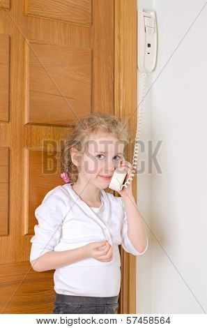 Little Girl Talking On The Intercom At Home.