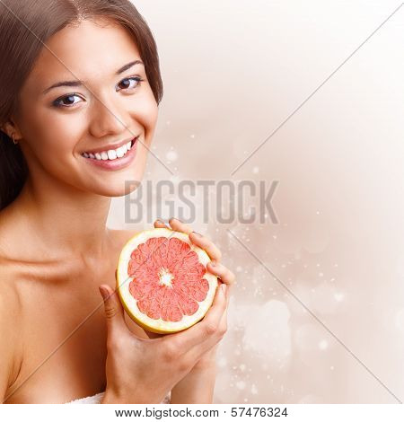 beautiful woman holding half of grapefruit