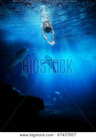 Young woman swimming with skarks in the ocean