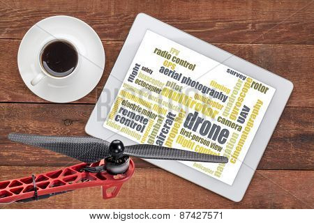 drone word cloud on a digital tablet with a cup of coffee and a drone propeller