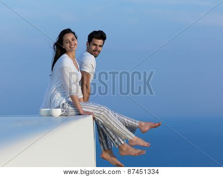 happy young romantic couple have fun relax smile at modern home outdoor terace balcony terace