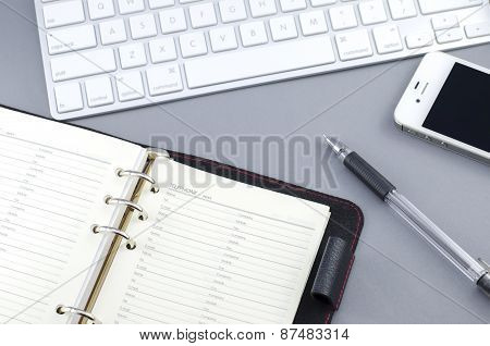Personal Organizer Address Book With Pen And Smart Phone On Computer Desk