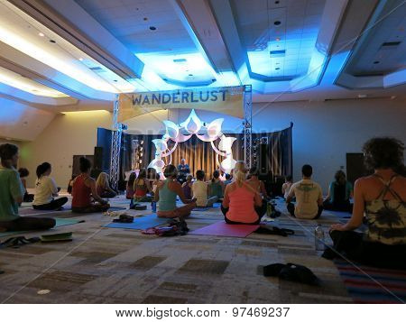 Author And Teacher Max Storm Teaches Yoga Class From A Stage To A Room Filled With Students Indoors
