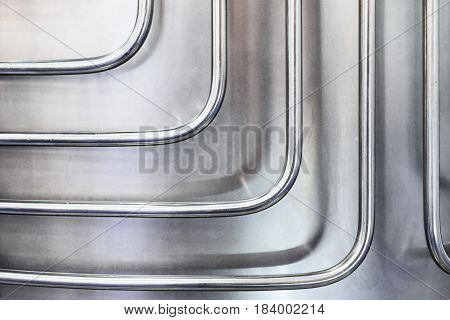 Thin metal tubes curved at right angles. Abstract industrial background.