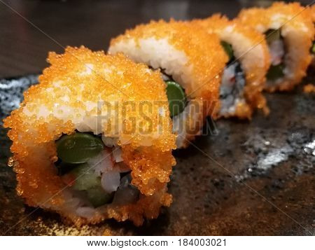 Fusion California roll sushi stuff with salmon cucumber crab stick and sweet egg Stylist food with blur boken background closed up Japanese sushi roll focus-on-foreground with blur background