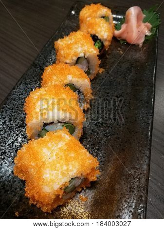 Fusion California roll sushistuff with salmoncucumbercrab stick and sweet eggStylist food with blur boken backgroundJapanese sushi rollfocus-on-foreground with blur background