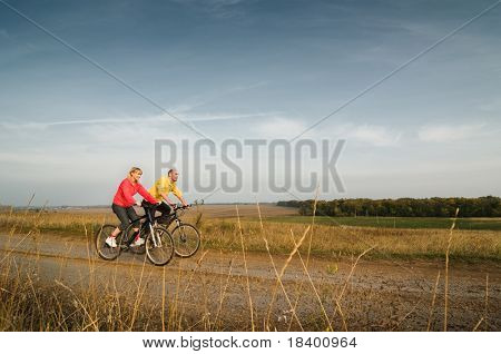 dvě cyklista uvolnit kole při západu slunce