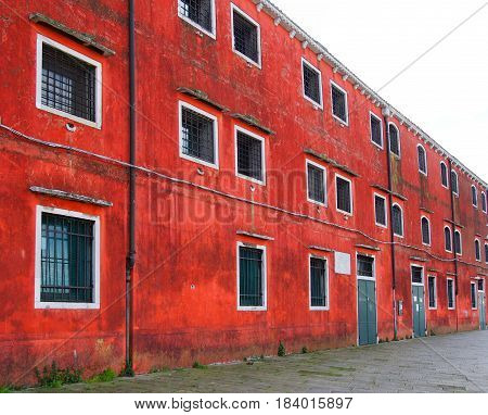 old red building in venice with square barred windows and doors