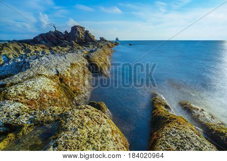 Long exposure of sea & rocks during beautiful evening at Labuan island,Malaysia.Known as Bonsai lonely tree Layang Layangan & lconic landmark in Labuan island,Malaysia.