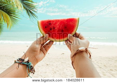 Relaxation and Leisure in Summer - Lifestyle image of tanned woman holding a watermelon On hands many seashell bracelets. Tropical island beach. Summer vacation concept. vintage color tone.