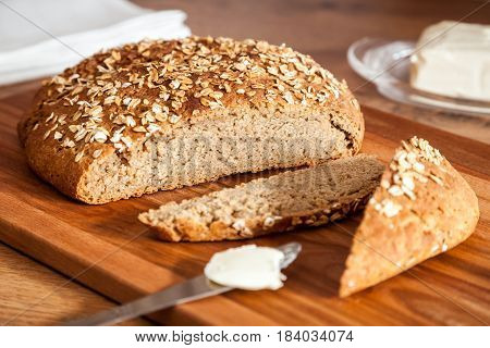 Healthy rye-wheat sourdough bread. Homemade whole grain fitness bread sprinkled with oat flakes closeup