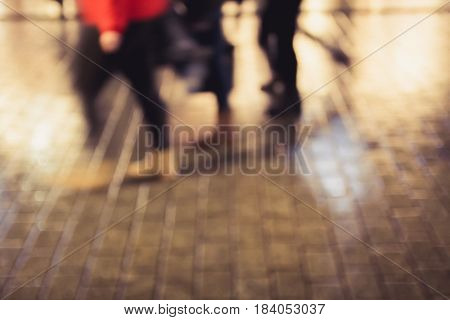 Blurred people walking in an old cobbled pedestrain street in a european city (vintage tone)