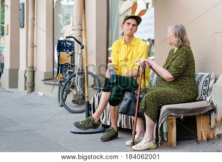RIGA LATVIA - MAY 24 2014: Miera street Pentecost. Unknown people sat on the roadside and talked.