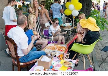 RIGA LATVIA - MAY 24 2014: Miera street Pentecost. Street side of the cafe unknown people enjoying lunch.