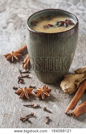 Traditional Indian Masala Tea In Ceramic Cup With Spices To Milk