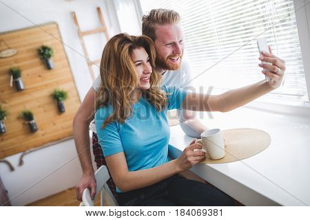 Romantic couple in love taking selfies and smiling at hime