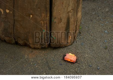 On the ground there is a red-hot metal billet