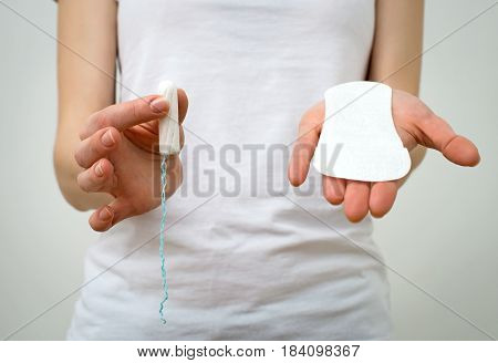 Woman Holding Sanitary Napkin And Tampon In Her Hands.