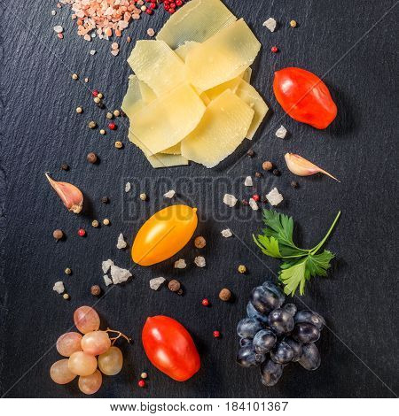 Top View Of Tasty Fresh Yellow Thin Slice Parm Cheese, Grapes,  Dry Pepper, Himalayan Salt, Tomatoes