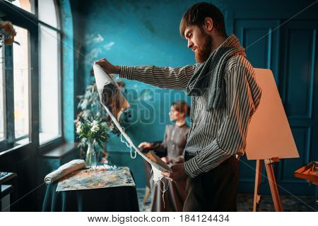 Painter looking at canvas painting against poseur