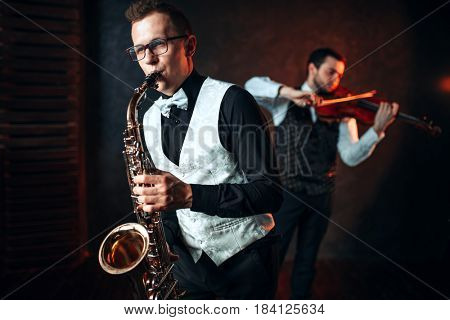 Sax man and fiddler duet playing classical melody