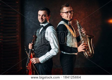 Saxophonist with sax and violinst with violin duet