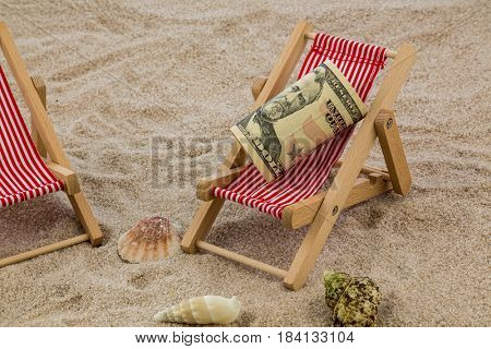 deckchair with piggy bank and dollars