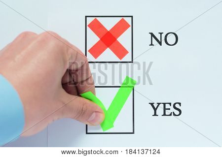 Yes No tickbox with green red tick. Hand holding marker