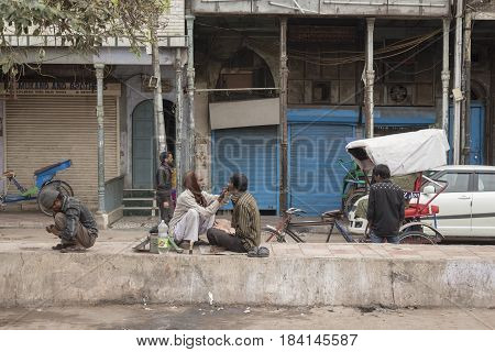 DELHI INDIA-MAR 15 : street barber at chandni chowk. this service is only in the morning. chandni chowk is famous market of Delhi on march 15 2015 india