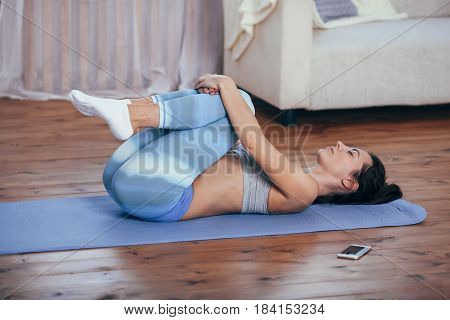 Young cheerful attractive woman practicing yoga, working out wearing sportswear